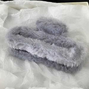 Close-up of grey plush hair claw clip made of soft faux fur for autumn winter hairstyles