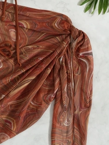 Close-up of brown marble print mesh fabric with drawstring ties on bikini skirt