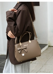 Detail of dark taupe PU leather handbag with lychee texture and star charm
