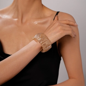 Detail view of a wide tortoiseshell resin bracelet with marble texture and geometric links