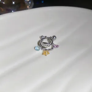 Orecchino d'argento Lucky con ciondoli in cristallo blu, giallo e viola su porcellana bianca