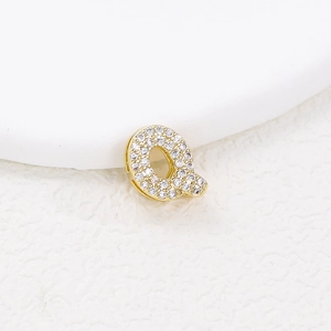 Macro shot of bubble letter Q gold pendant with pave-set zircon stones and tiny stones