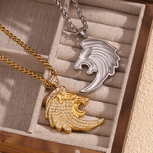 Détail de pendentifs tête de lion en or serti de diamants et finition argent brossé
