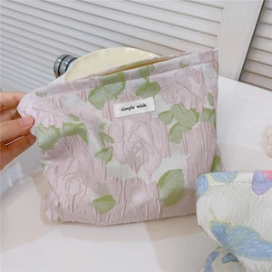 Detail showing the floral jacquard fabric and simple wish label on the makeup bag