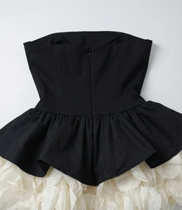 Detail of multi-layered white mesh floral ruffles on a black bustier evening dress