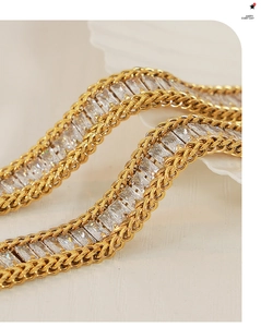 Detailed macro of gold titanium bracelet with inlaid baguette zircons and woven edges
