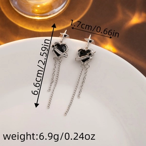 Close-up of silver star and black heart tassel earrings with size dimensions details
