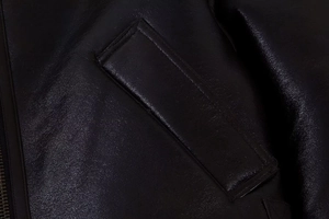 Vue macro détaillée de la poche zippée et du grain de cuir de la veste en cuir noir