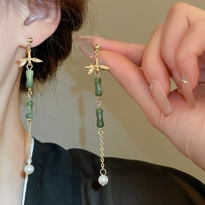 Detailed view of long Chinese bamboo tassel earrings with green jade beads and pearls