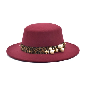 Détail d'un chapeau en laine bordeaux avec ruban léopard et ornements de perles