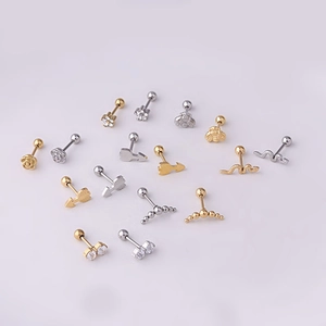 Flat lay of 20G stainless steel stud earrings featuring flower bee and snake shapes in gold
