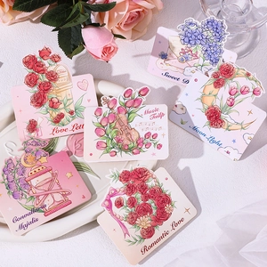 Detailed view of six floral greeting cards with rose and tulip designs in a romantic setting