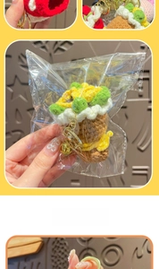 Close-up of handmade crochet sunflower keychain with golden bell and metal clip