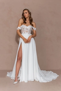 Detail of elegant white lace corset with high slit skirt and long train wedding dress