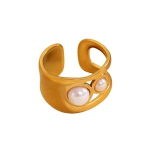 Detail of gold open ring with irregular cut-out design and two inset white pearls