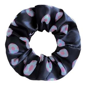 Vue détaillée du chouchou en satin noir avec motifs de football rose et bleu