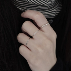 Close-up of three minimalist 925 silver rings layered on a hand for a trendy daily look