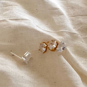 Minimalist 925 sterling silver stud earrings with sparkling cubic zirconia on soft fabric