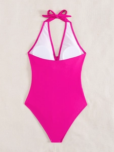 Detail of rose pink one-piece swimsuit featuring built-in white pads and halter neck ties