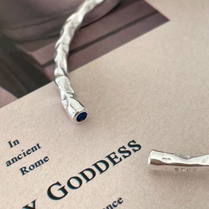 Irregular textured S925 silver open bracelet featuring a blue gemstone and matte finish