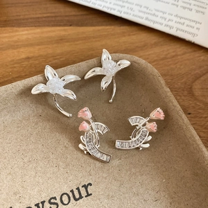 Detailansicht der Blumenohrringe und geschwungenen Kristallstecker mit Rosenknospen