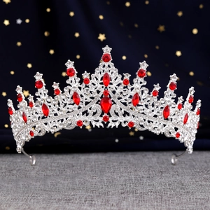Macro shot of silver bridal crown featuring red crystal gemstones and intricate rhinestone detail
