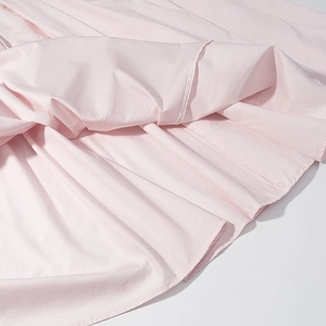 Gros plan détaillé montrant les coutures de qualité et la texture du tissu de l'ourlet rose