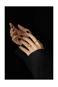 Close-up of elegant gold moonstone ring set with minimalist bead design on fingers