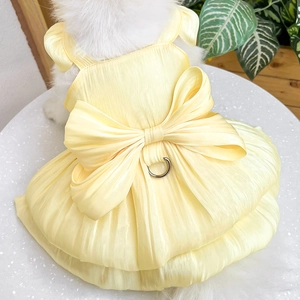 Detail of yellow pet dress featuring a large bow and metal D-ring for leash attachment