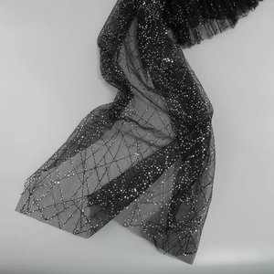 Detail of black mesh fabric with sparkling silver sequins and geometric pattern