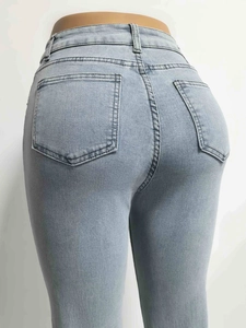 Detail view of the back pockets and high-waist stitching on light blue denim flare jeans