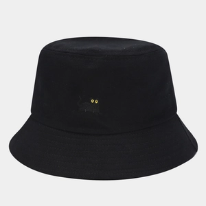 Close-up detail of a black cat embroidery with yellow eyes on a cotton bucket hat