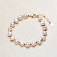 Detailed macro view of baroque freshwater pearls and golden beads with lobster clasp closure