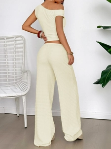 Back view of textured knit two-piece set with one-shoulder top and wide-leg trousers