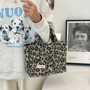 Detailed view of leopard print tote bag with soft plush texture and brand label