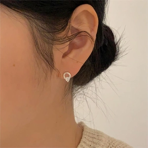 Close-up of minimalist silver hoop earrings with clear cubic zirconia on female model
