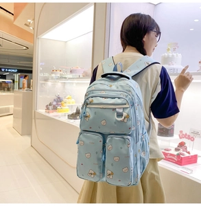 Detail of light blue student backpack with cute bear prints and multi-pocket design