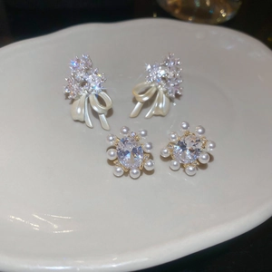 Macro view of 14k gold plated earrings featuring sparkling zircons and delicate pearls