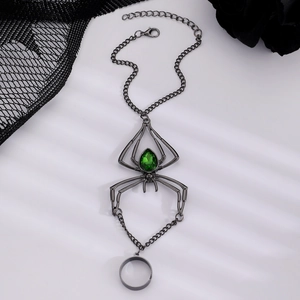 Detail of gothic spider hand harness with emerald green gem and gunmetal chain links