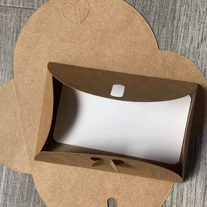 Vintage kraft paper envelope with heart-shaped buckle and white card insert