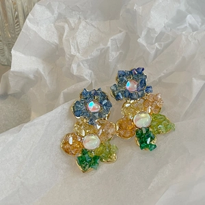 Vue macro détaillée de boucles d'oreilles fleurs colorées avec cristaux et perles
