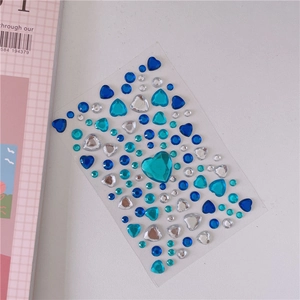 Macro shot of blue and clear heart-shaped acrylic crystal stickers for DIY crafts