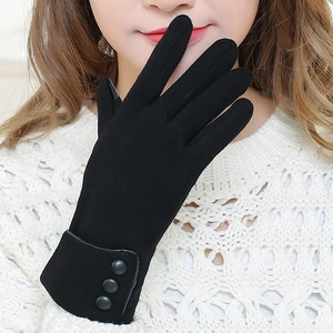 Close-up of black fleece gloves with decorative wrist buttons and warm texture