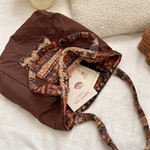 Macro detail of brown tote bag showing its fuzzy plaid interior and durable nylon texture
