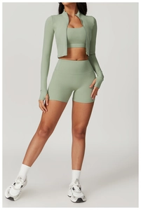 Detail of sage green yoga set showing zip-up jacket with thumbholes and high-waist shorts