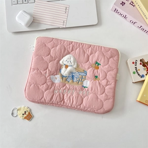 Detalle del bordado de cachorro de peluche y texto Happy Day en funda rosa acolchada