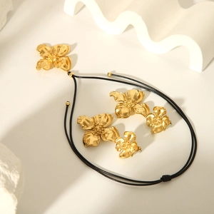 Detail of 18K gold-plated flower jewelry set with necklace and matching stud earrings