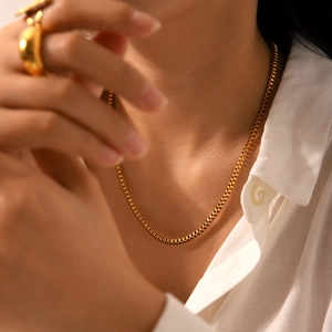 Close-up of minimalist gold-plated stainless steel box chain necklace on model