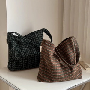 Detailed texture of retro plaid and striped fabric tote bags with a minimalist brand label