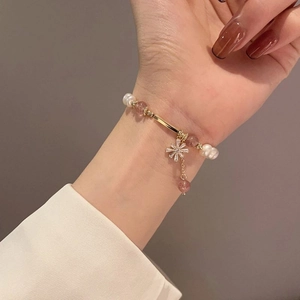 Detail of baroque pearl bracelet with pink beads and snowflake zircon charm on wrist